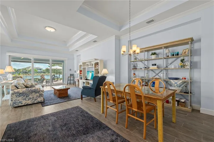 Dining space with a notable chandelier, a tray ceiling, and ornamental molding