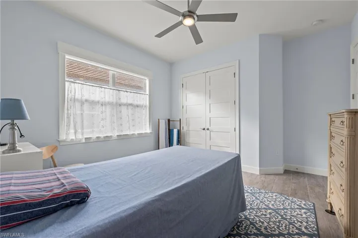 Bedroom featuring ceiling fan, a closet, and light wood-type flooring