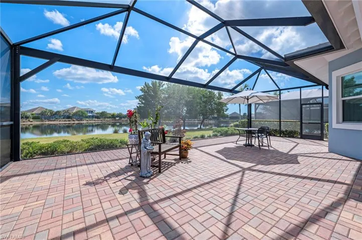 View of patio with a water view and glass enclosure
