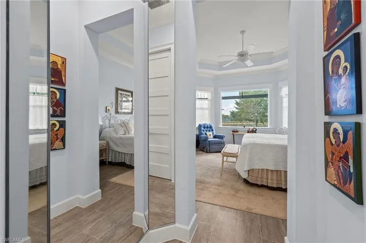 Bedroom featuring crown molding, ceiling fan, a raised ceiling, and light hardwood / wood-style flooring