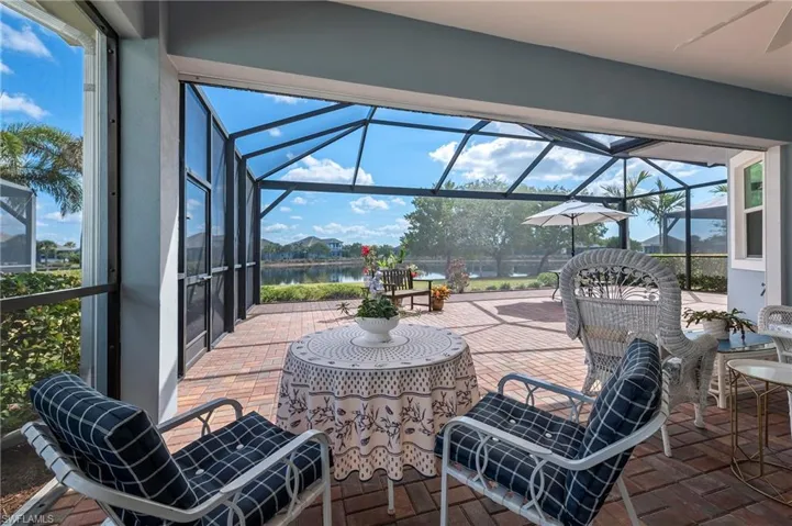 View of patio with a water view and glass enclosure