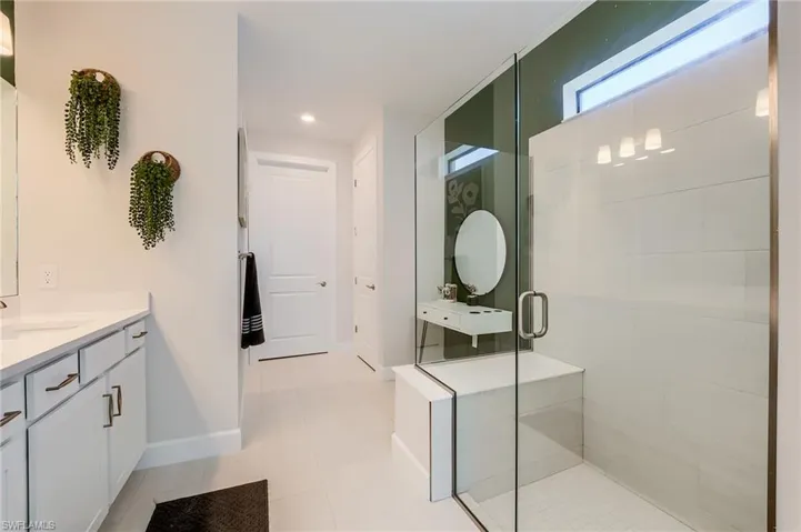 Bathroom with tile patterned floors, vanity, and an enclosed shower