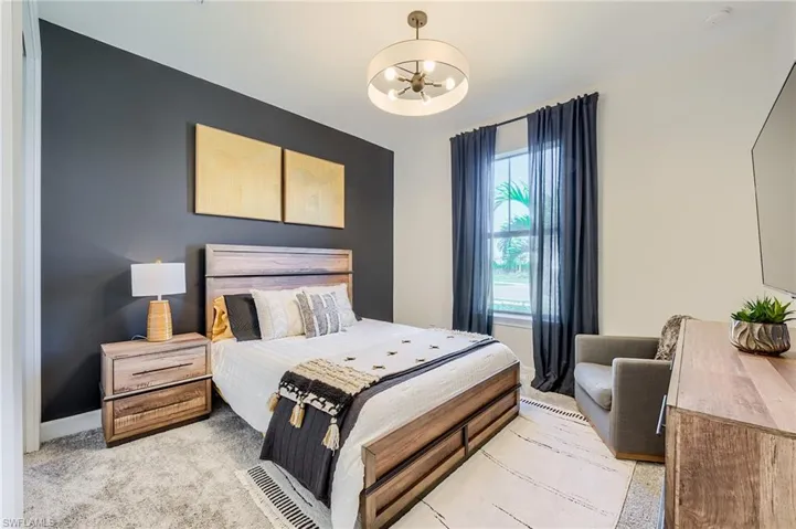 Bedroom featuring a chandelier and light carpet