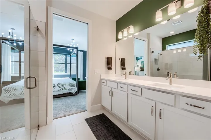 Bathroom featuring tile patterned flooring, vanity, and a shower with shower door
