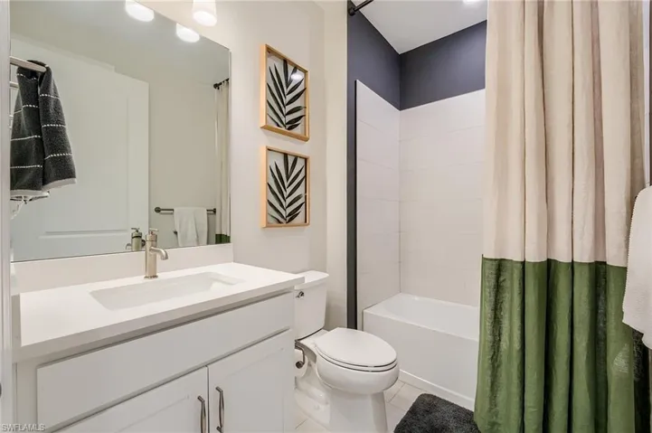 Full bathroom featuring tile patterned floors, vanity, shower / bath combo, and toilet