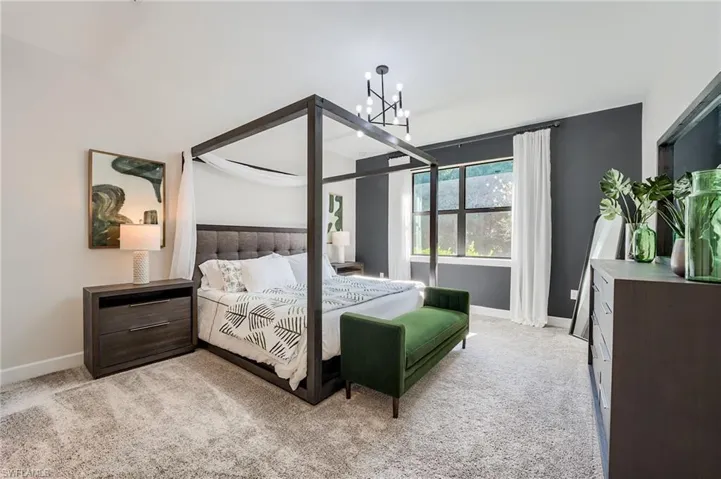 Carpeted bedroom featuring an inviting chandelier