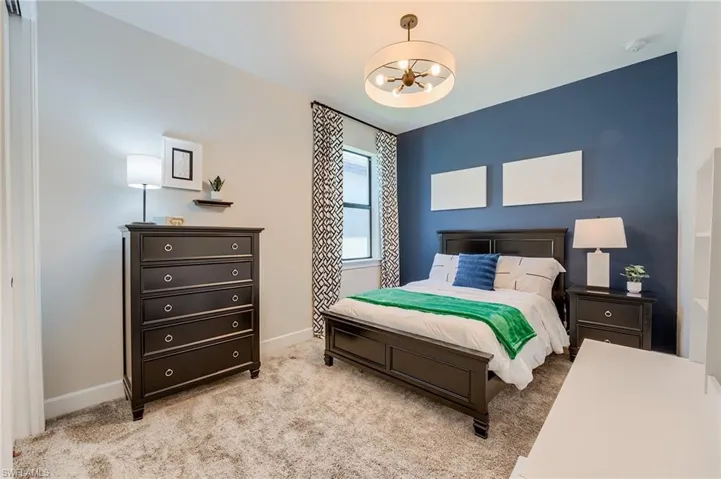 Carpeted bedroom with a chandelier