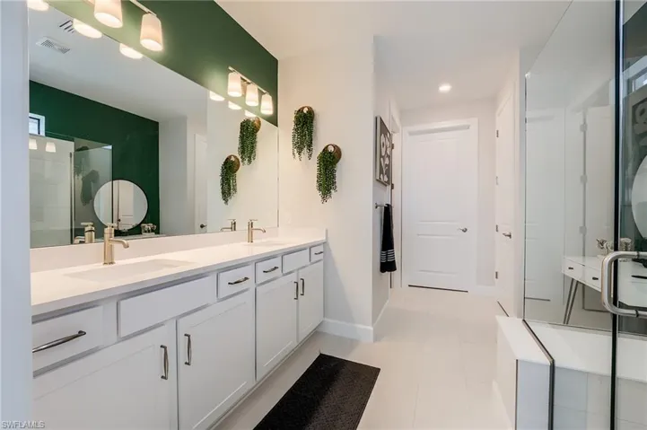Bathroom featuring tile patterned flooring, vanity, and walk in shower