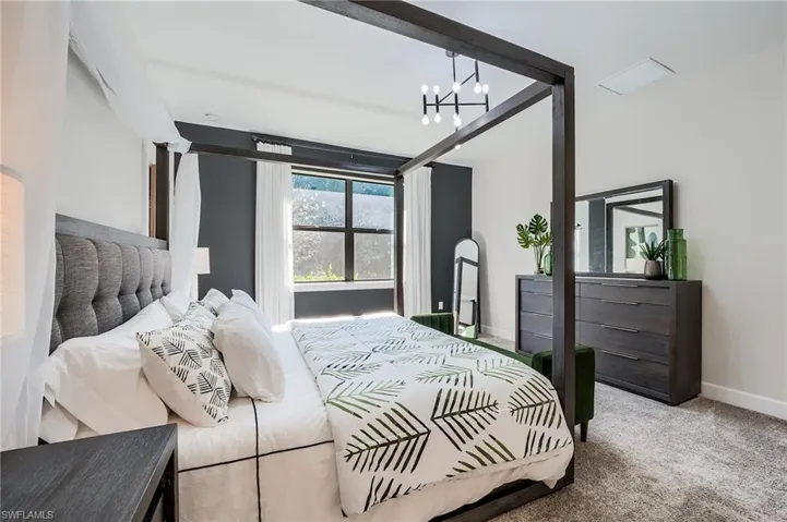 Carpeted bedroom with an inviting chandelier