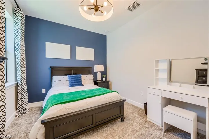 Bedroom featuring a chandelier and light colored carpet