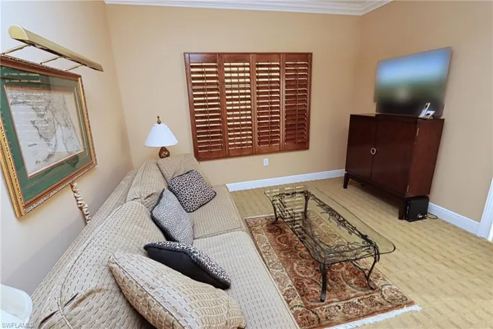 Carpeted living room with ornamental molding