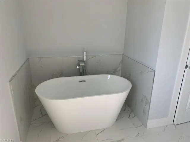 Bathroom featuring tile walls and a washtub