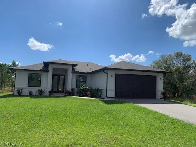 View of front of property featuring a front yard and a garage