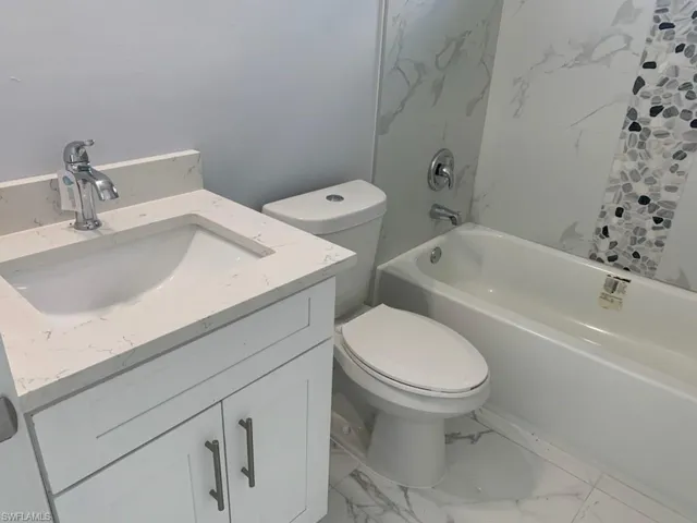 Full bathroom with vanity, toilet, and shower / bathtub combination with curtain
