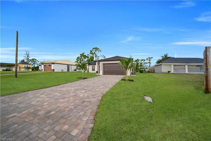 View of front of property with a front yard and driveway