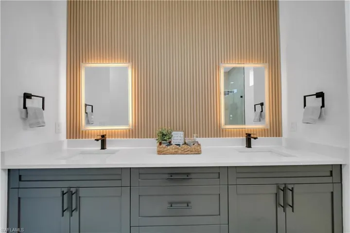Full bath with double vanity and a shower
