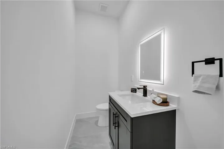 Bathroom featuring marble look tiles and vanity