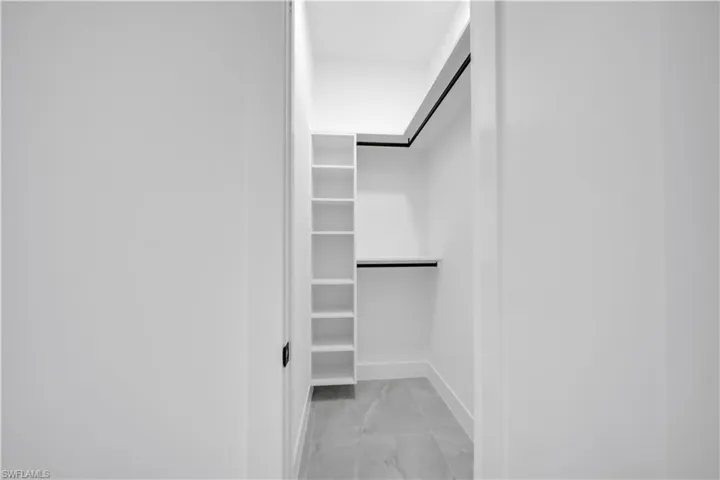 Walk in closet with light marble finish floors