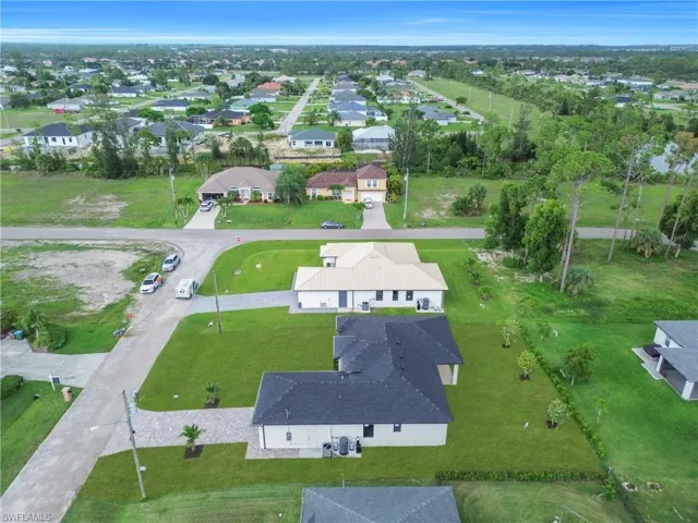 Aerial view of property and surrounding area with nearby suburban area