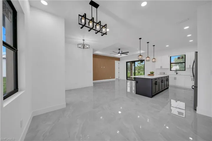 Kitchen with white cabinets, recessed lighting, a chandelier, a center island, and light countertops