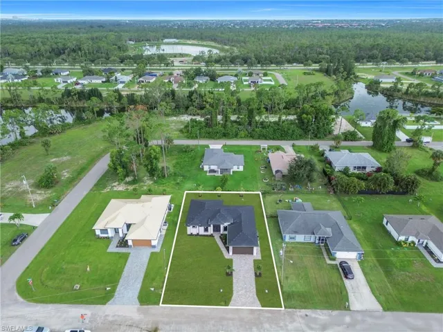 Aerial view of property's location featuring a large body of water and nearby suburban area