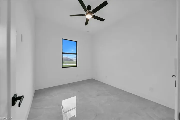 Spare room featuring ceiling fan and baseboards