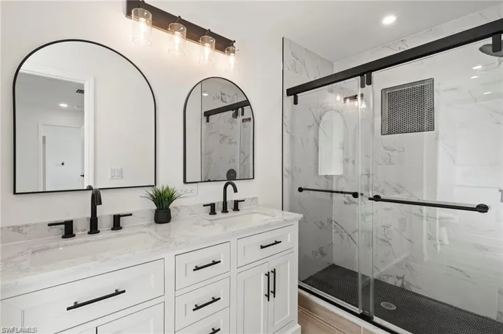 Bathroom with vanity, hardwood / wood-style floors, and a shower with door