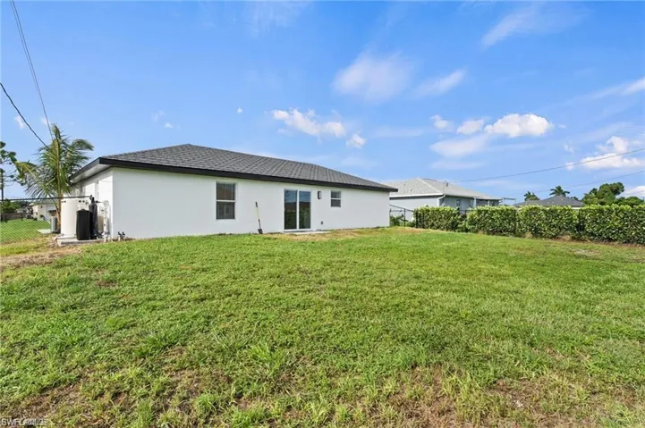 Back of property featuring a lawn
