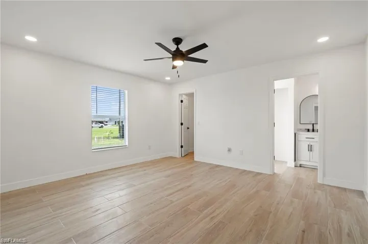 Empty room with ceiling fan and light hardwood / wood-style floors