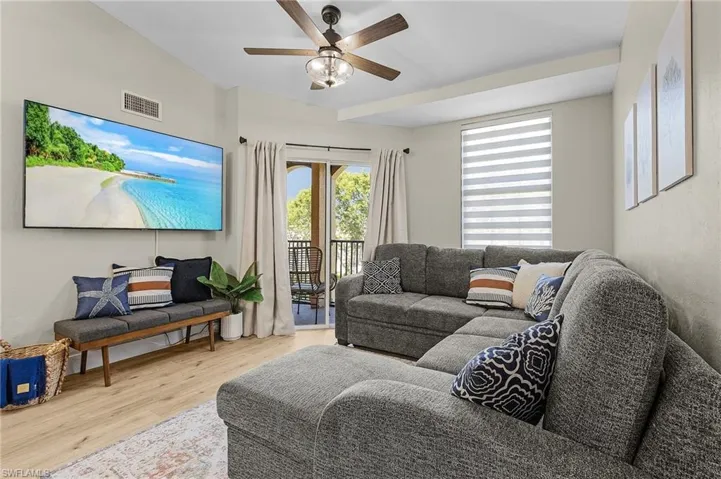 Living room featuring ceiling fan, visible vents, and wood finished floors