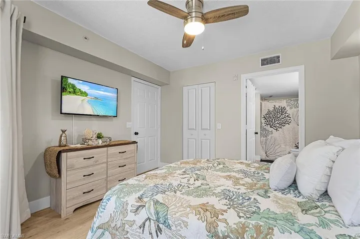 Bedroom featuring light wood finished floors, a closet, visible vents, a ceiling fan, and baseboards