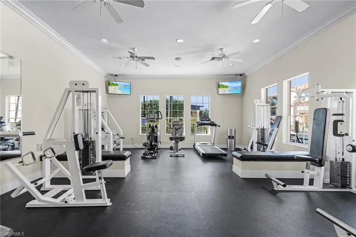 Workout area with ornamental molding, recessed lighting, a wealth of natural light, and baseboards