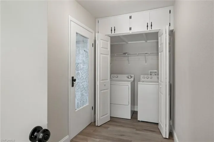 Washroom featuring light hardwood / wood-style floors and washer and clothes dryer