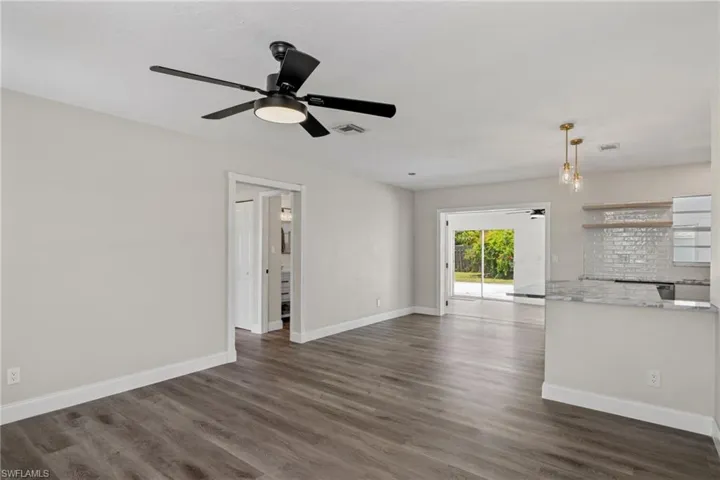 Unfurnished living room featuring dark hardwood / wood-style floors and ceiling fan
