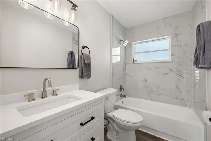 Full bathroom featuring vanity, toilet, wood-type flooring, and tiled shower / bath