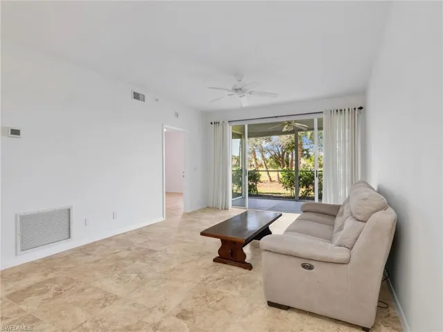 Living area featuring baseboards and ceiling fan