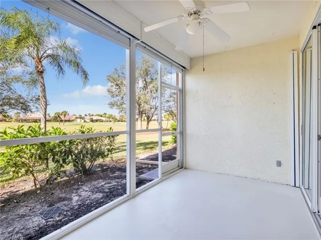 Unfurnished sunroom with ceiling fan and view of golf course