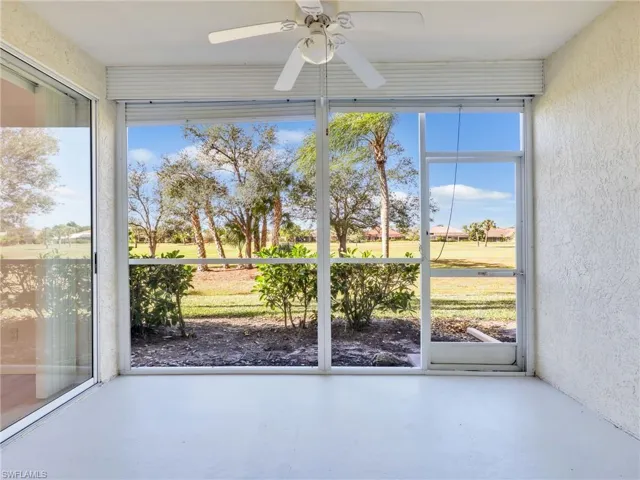 Unfurnished sunroom with a textured wall, concrete flooring, and plenty of natural light