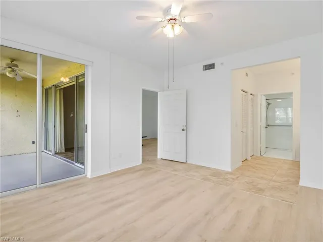 Unfurnished bedroom featuring wood finished floors, a ceiling fan, and ensuite bathroom