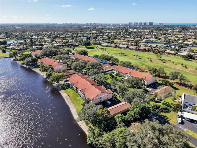 Aerial perspective of suburban area with a nearby body of water and a golf club