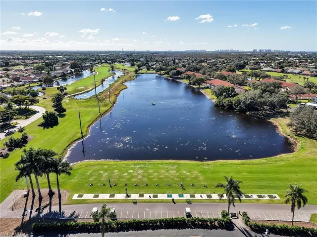 Aerial perspective of suburban area with a large body of water and a local golf course