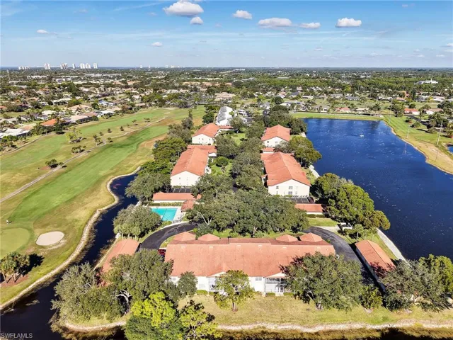 Aerial view of property's location with a golf course and nearby suburban area