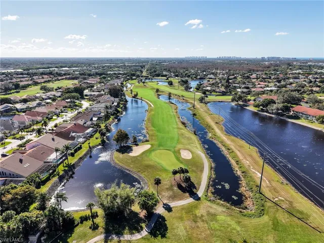 View of property location with a nearby body of water, a local golf course, and nearby suburban area