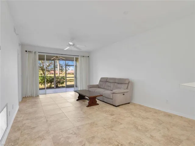 Living area with ceiling fan and baseboards