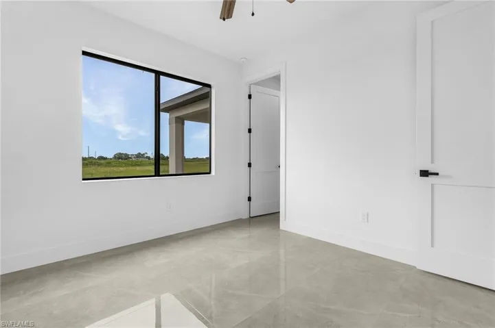 Unfurnished room with light tile patterned floors and ceiling fan