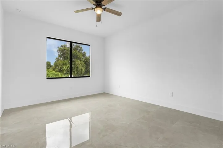 Tiled empty room featuring ceiling fan