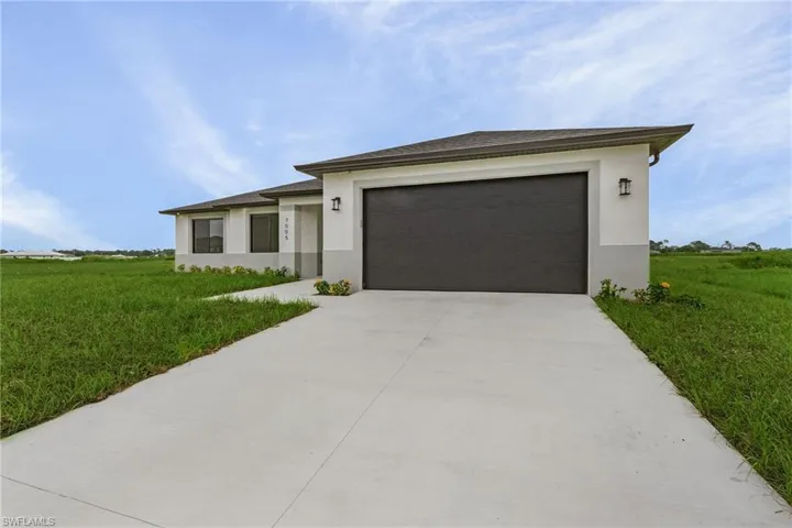 View of front of property featuring a garage and a front yard