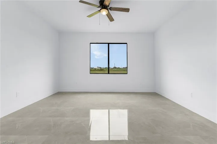 Tiled empty room with ceiling fan