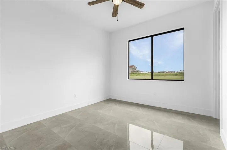 Empty room featuring ceiling fan and light tile patterned flooring