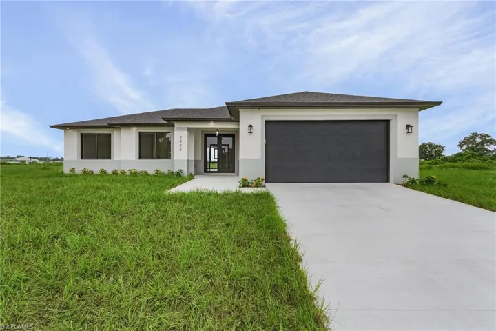 View of front of property featuring a garage and a front yard
